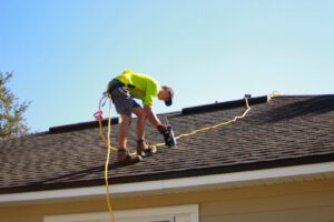 a man working on a roof with a power drill